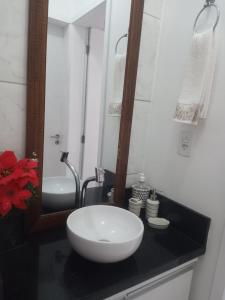 a bathroom with a white sink and a mirror at Apto 304 sc in Palhoça +22 photos
