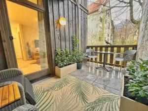 a balcony with a table and chairs and plants at HIRSCH Stadt Apartment 2 - Terrasse mit Flussblick - Parkplatz in Bad Harzburg +18 photos