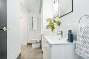 Quiet & Cozy 4 Bedroom Home في Norlane: حمام أبيض مع مرحاض ومغسلة