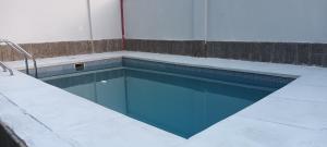 a swimming pool with blue water in a building at Casa Sol de los Andes in Mendoza