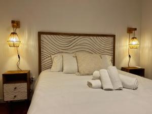 a bedroom with a large white bed with two lamps at Cantinho do Castelo in Bragança