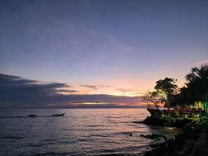 a sunset over a body of water with a boat at Hostal Oklahoma 48 in Necoclí