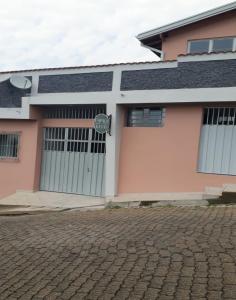 a pink house with a gate and a brick driveway at Espaço Kayan in Cunha +22 photos