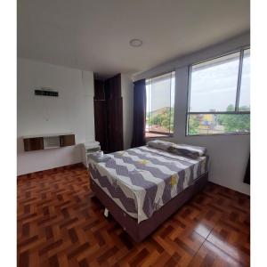 a bedroom with a bed in a room with windows at Casa de Campo Santo Tomas in Iquitos +24 photos
