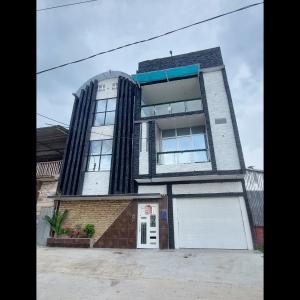 a tall building with a white garage at Casa de Campo Santo Tomas in Iquitos