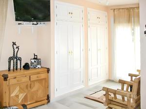 a living room with white cabinets and a flat screen tv at Elegant Villa in Nuevo Portil with Shared Pool in El Portil