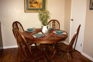 a dining room table with chairs and a vase on it at Carlton Club Inn in Kerrville