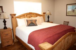 a bedroom with a wooden bed and a window at Carlton Club Inn in Kerrville