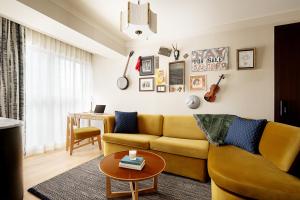 a living room with a yellow couch and a table at Hutton Hotel in Nashville
