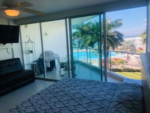 a bedroom with a bed and a view of a pool at Aria Ocean Beachfront Condos in Nuevo Vallarta