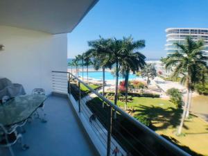 a balcony with a view of the beach and palm trees at Aria Ocean Beachfront Condos in Nuevo Vallarta