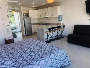 a bedroom with a bed and a kitchen at Aria Ocean Beachfront Condos in Nuevo Vallarta