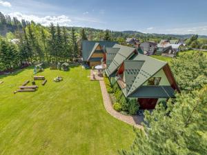 ツァルナ・グラにあるHacjenda - Apartamenty i Pokoje Gościnneの緑地の家屋