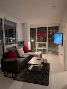 a living room with a couch and a flat screen tv at Modern 2 bedroom condo with AC in Olympic Village in Vancouver