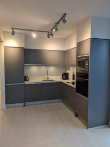 a kitchen with gray cabinets and a microwave at Modern 2 bedroom condo with AC in Olympic Village in Vancouver