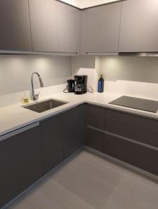 a kitchen with white cabinets and a sink at Modern 2 bedroom condo with AC in Olympic Village in Vancouver +19 photos