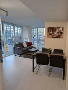 a living room with a couch and a table at Modern 2 bedroom condo with AC in Olympic Village in Vancouver