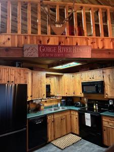 a kitchen with black appliances and wooden cabinets at Rustic 5 Bedroom Gorge River Resort in Walhalla