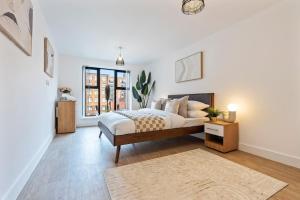 a white bedroom with a bed and a window at The Grand Central Penthouse - Luxury - Sleeps 4 in Birmingham