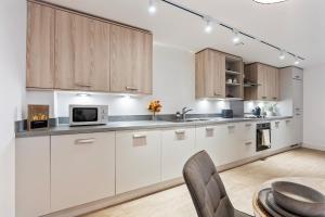 an empty kitchen with white cabinets and a table at The Grand Central Penthouse - Luxury - Sleeps 4 in Birmingham