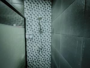 a shower in a bathroom with a tile wall at Pachira Living Legian - Monthly Rate Available in Legian +14 photos