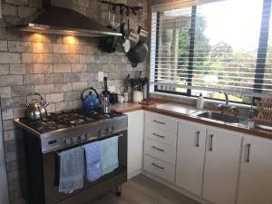 a kitchen with a stove and a sink at Nikau Nook in Raglan +16 photos