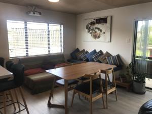 a living room with a table and a couch at Nikau Nook in Raglan