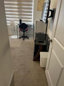 a room with a desk with a television and a chair at Cozy Suite in Oshawa +5 photos