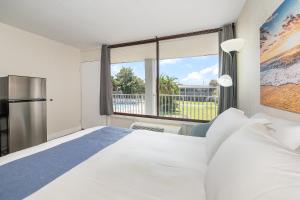 a bedroom with a large bed and a large window at Charming Suite: Smart TV, Modern Amenities & Pool Access in Kissimmee +7 photos