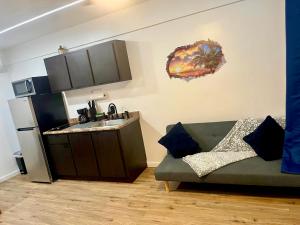 a living room with a green couch and a refrigerator at Modern Oceanfront Apartment in Arecibo