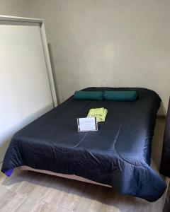 una cama con un edredón azul y una señal en ella en Alquiler, en Colonia Las Rosas