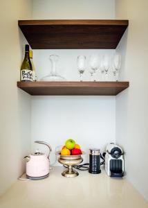 a shelf with wine glasses and a bowl of fruit at Amazing room #3 in Queenstown +11 photos