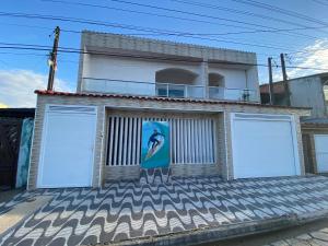 a building with two garage doors on the side of it at Hostel Altas Ondas - 500m da praia in Itanhaém