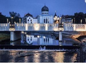 een brug over een rivier voor een gebouw bij Flux 2 in Oradea