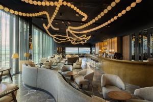 a lobby with couches and tables and a chandelier at Pullman Auckland Airport in Auckland