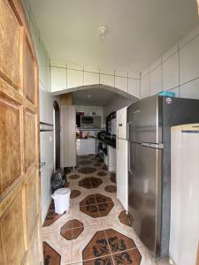 a kitchen with a refrigerator and a tile floor at Hostel Altas Ondas - 500m da praia in Itanhaém