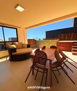 ein Wohnzimmer mit einem Holztisch und Stühlen in der Unterkunft MHV Milagres - Casa Aurora, Refugio a poucos metros da Paradisíaca Praia do Marceneiro in Passo de Camarajibe