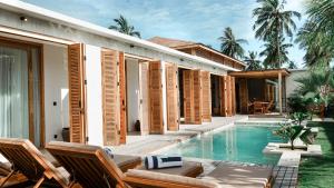 a villa with a swimming pool next to a house at Villa Elior Selong Belanak, South Lombok in Selong Belanak