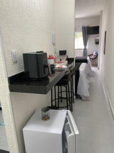 a small kitchen with a counter with a microwave at MAHALO 1004 Suites in Maricá +5 photos