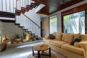 a living room with a couch and a table at Raya Villa by Betterplace in Canggu