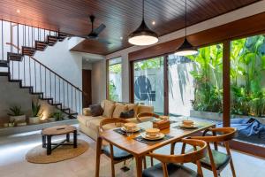 a living room with a table and a couch at Raya Villa by Betterplace in Canggu