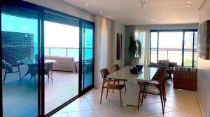 a dining room and living room with a table and chairs at Landscape@UrbanBeach -200 m² de puro luxo in Fortaleza