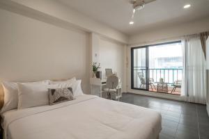 Un dormitorio con una gran cama blanca y un balcón. en 4BR Walk to Chinatown, MRT Luggage Dropoff, en Bangkok