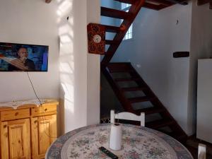 a dining room with a table and a spiral staircase at Big House in Merlo