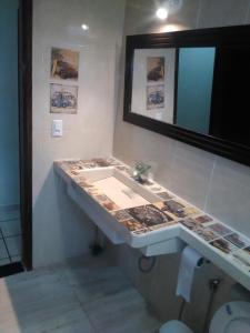 un baño con lavabo y espejo en Paz, en Peruíbe