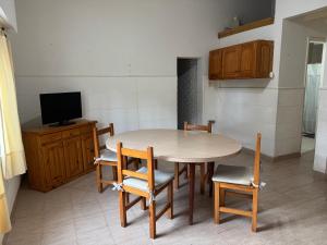 eine Küche mit einem Tisch und Stühlen sowie einem TV in der Unterkunft Casa playa Valeria in Valeria del Mar + 6 Fotos
