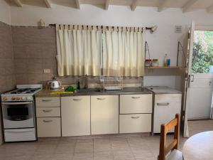 eine Küche mit Spüle und Herd in der Unterkunft Casa playa Valeria in Valeria del Mar
