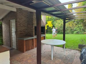 eine Pergola mit einem Tisch und einem Grill im Hof in der Unterkunft Casa playa Valeria in Valeria del Mar