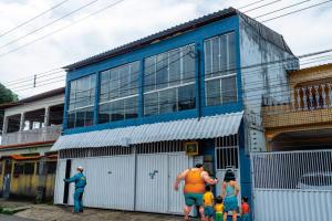 a group of people standing outside of a blue building at Casa10inn hst in Serra