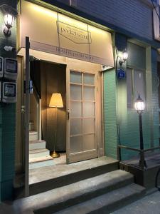 a building with a door and a lamp in front of it at Pocket Seoul Hostel Hongdae in Seoul